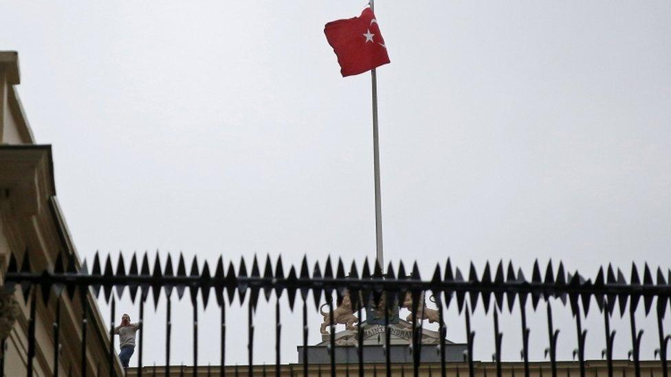 A protester (bottom left) shouts slogans after replacing the Dutch flag with a Turkish one at the Netherlands' consulate in Istanbul