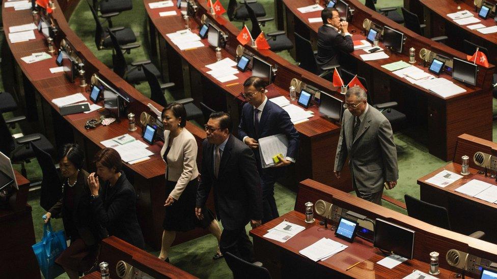 Pro-Beijing legislators walk out of the main chambers in protest against the second swearing-in of pro-independence lawmakers