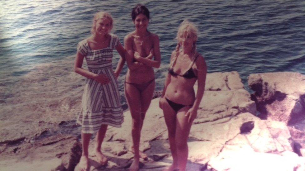 Denise Hayes and her two friends standing on a rock by the sea in Hydra, Greece