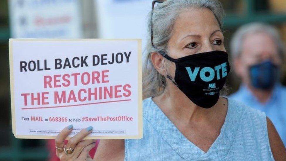 A protester calls for the reversal of cost-cutting measures at the US Postal Service, outside a post office in Royal Oak, Michigan (22 August 2020)