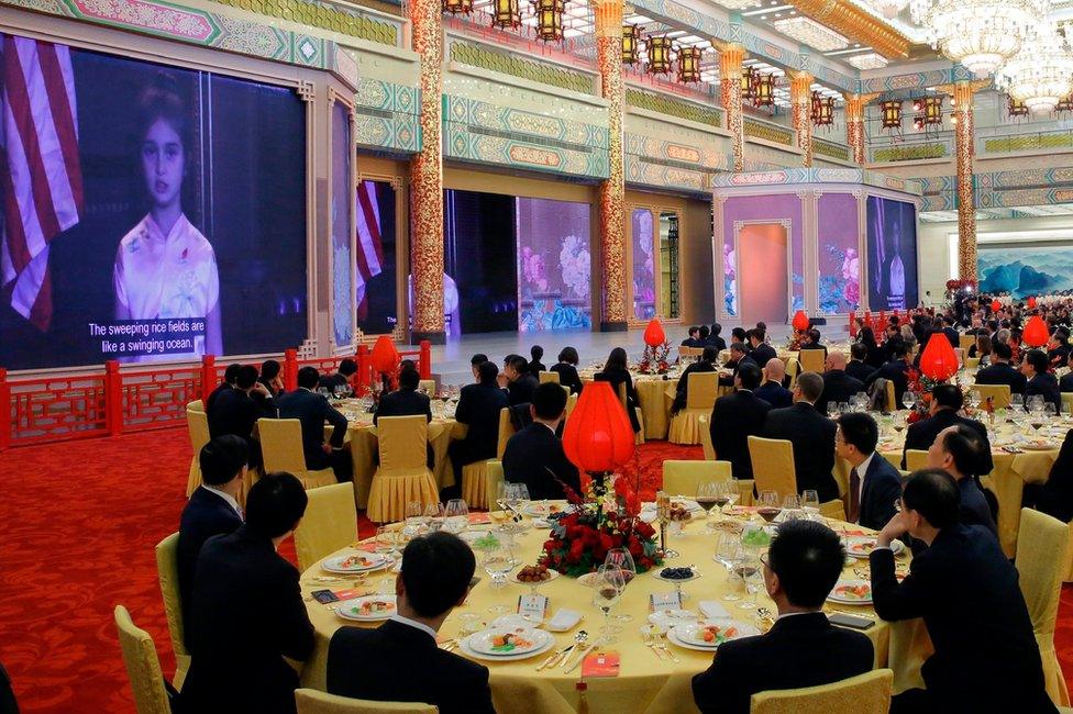 Guest watch a video of Arabella Kushner, granddaughter of US President Donald Trump, sing a traditional Chinese song during a state dinner at the Great Hall of the People in Beijing on 9 November 2017