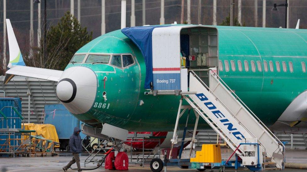 A person walks past an unpainted Boeing 737-8 MAX parked at Renton Municipal Airport adjacent to Boeing's factory in Renton, Washington on January 25, 2024.