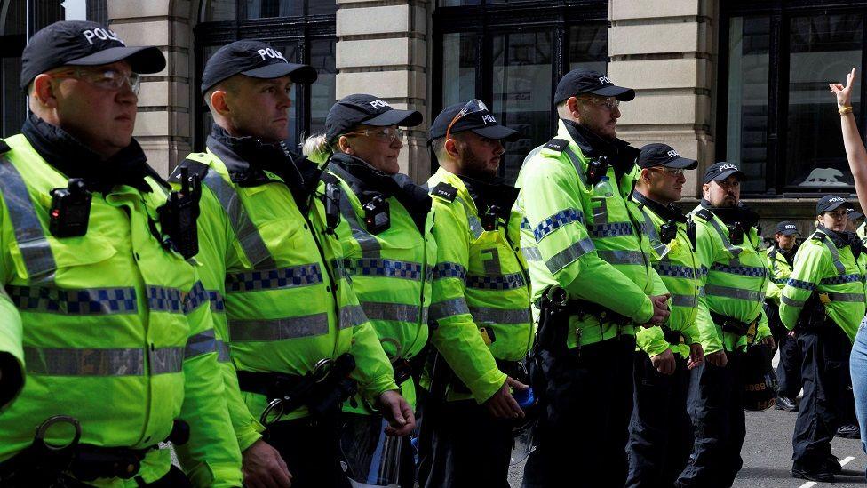 A line of police looking out at protesters in Liverpool, Britain, August 3, 2024.