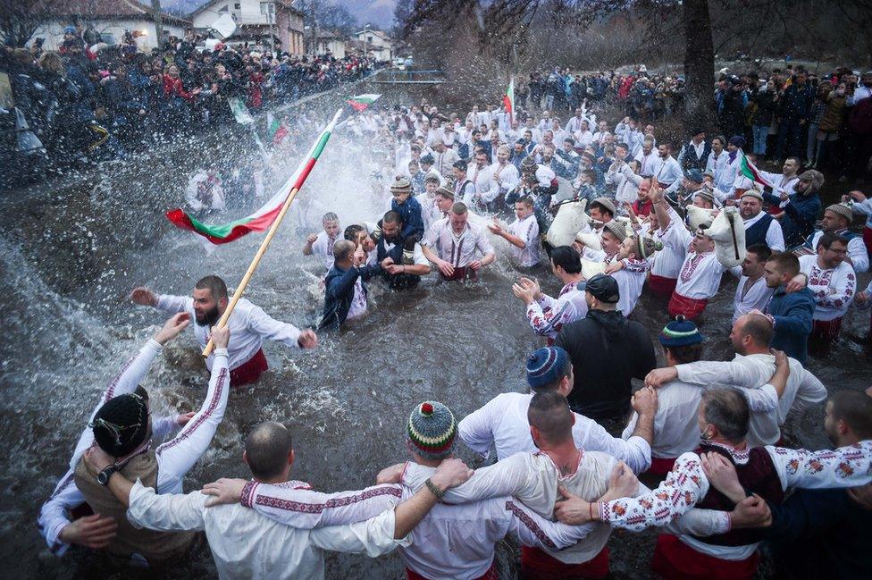 Bulgarian men perform the traditional "Horo" dance in the icy winter waters of the Tundzha river in the town of Kalofer, as part of Epiphany Day celebrations on 6 January 2021.