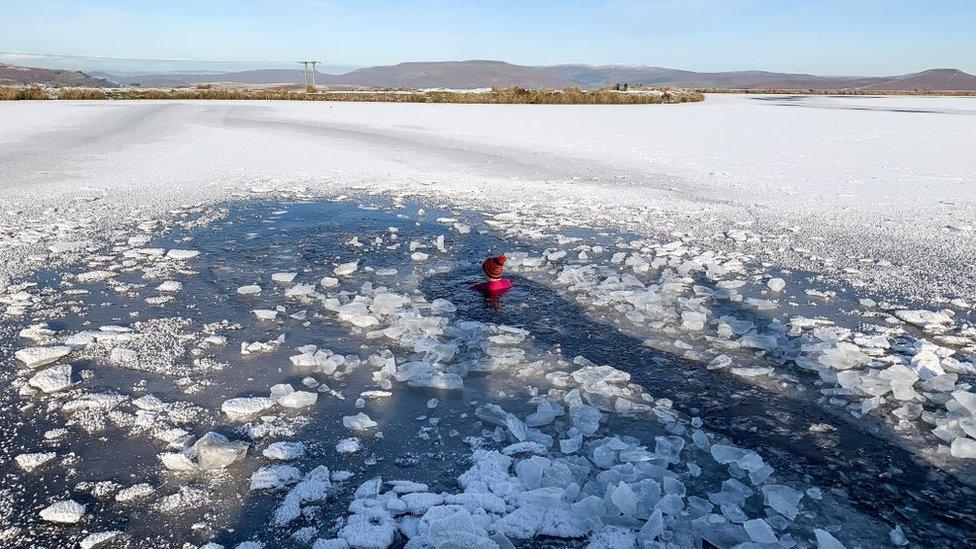 woman swimming in frozen pond