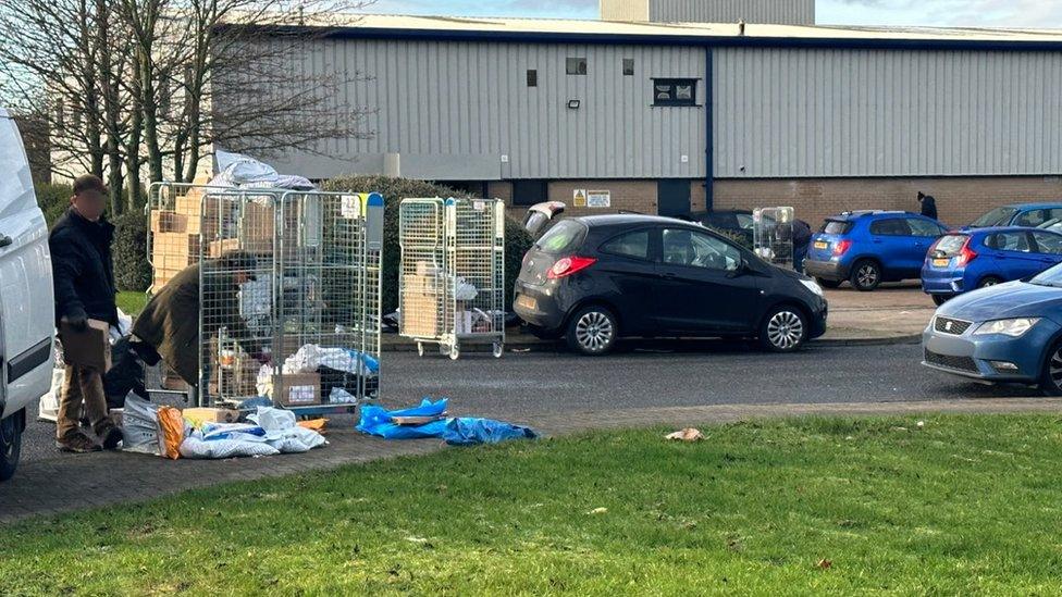 Parcels are in a metal cage outside waiting to be loaded into cars