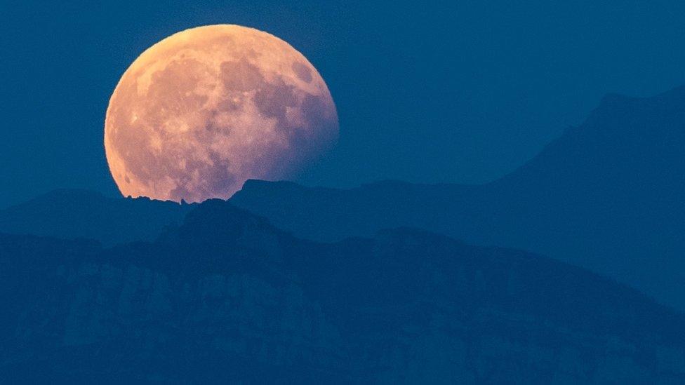 The full moon is seen during a partial lunar eclipse above the Bernese Alps, from Bern, in Switzerland, 07 August 2017.