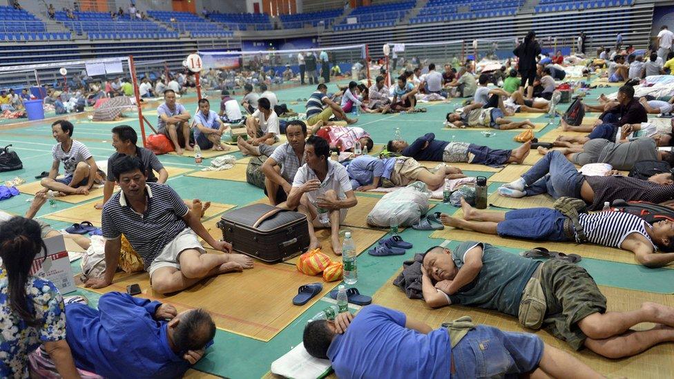 Chinese workers rest at Nansha Stadium as Typhoon Nida hit the area in Guangzhou