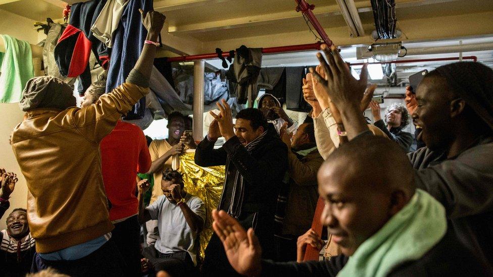 Migrants aboard the Dutch-flagged rescue Vessel "Sea Watch 3" sailing off Malta's coast, react on January 9, 2019 after it was announced that Malta has reached a deal with other EU member states to allow migrants onboard to disembark