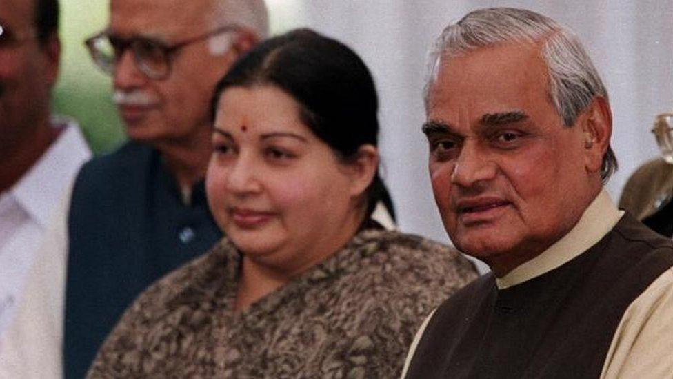 Hindu Nationalist Bharatiya Janata Party candidate for Prime Minister Atal Bihari Vajpayee,, comes out of his residence along with Jayalalitha Jayaram