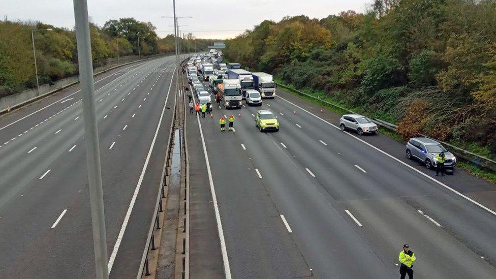 Cars seen queued up on the M25 after an environmental protester climbed a gantry