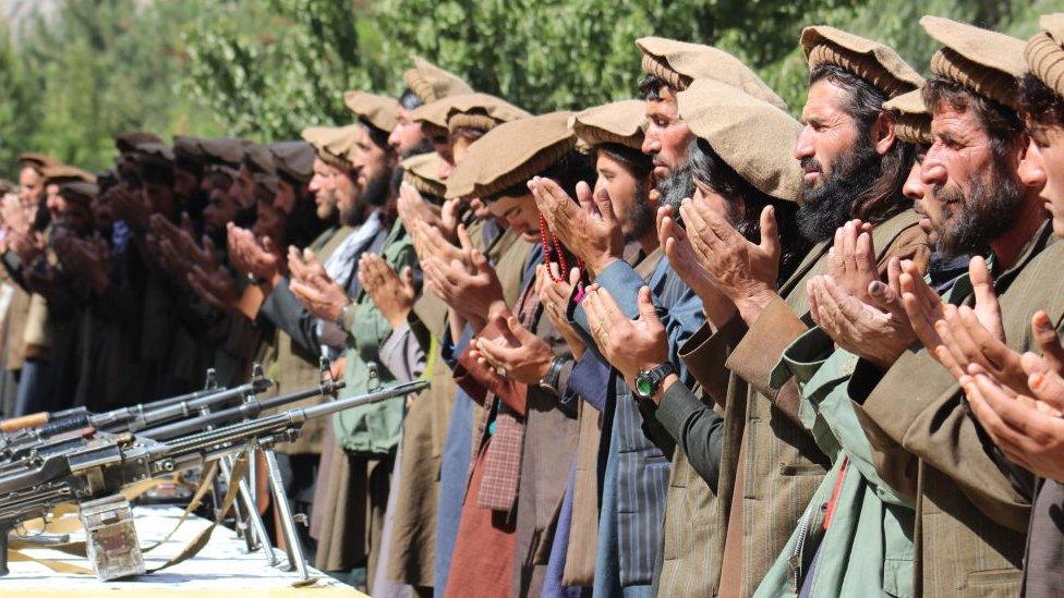 A group of Taliban soldiers praying after sacrificing their weapons and joining the Afghan government