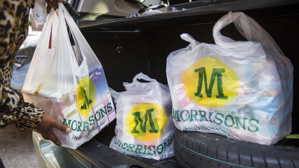 Morrisons shopping bags being placed in a car boot