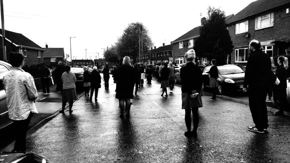 People stand apart in street to clap for nurse