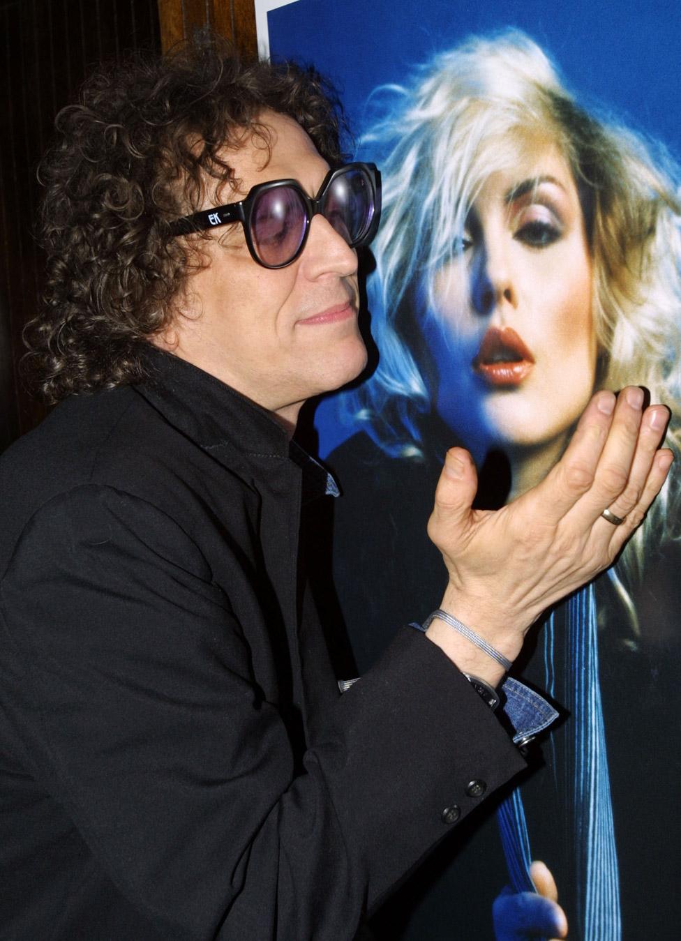 Mick Rock in 2004 with one of his photos of Blondie's Debbie Harry