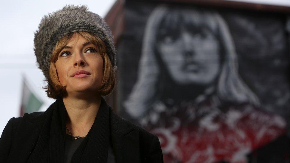 Gwenno Saunders alongside the mural featuring her face