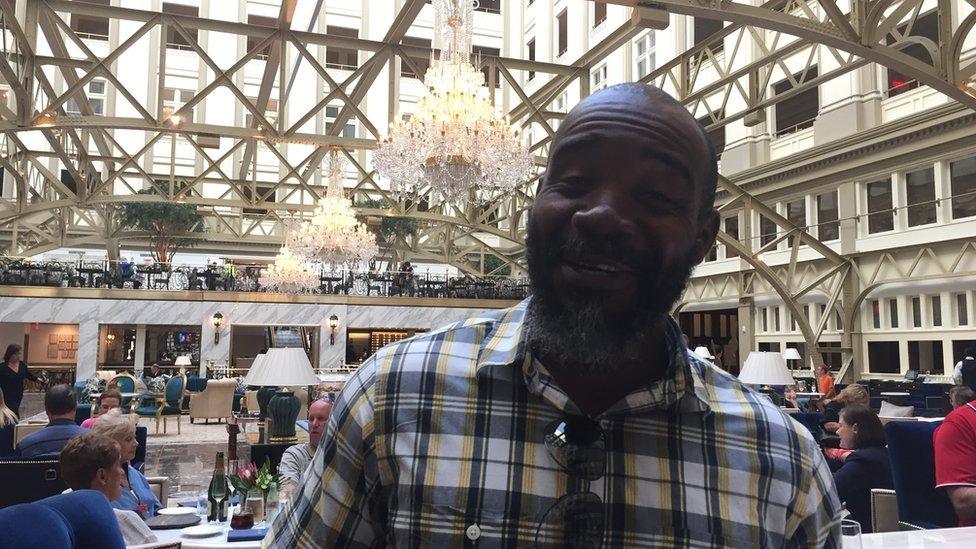 Felix Anyanwu sits at a bar in the Trump hotel in Washington, DC.