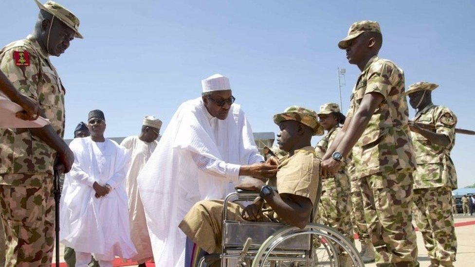 Nigerian President Muhammadu Buhari presents Lance Corporal Kenneth Kulugh with the Purple Heart medal for gallantry in the fight against Boko Haram (14 November 2015)