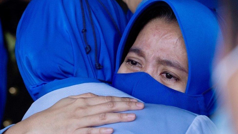 Families of the sunken KRI Nanggala-402 submarine"s crew members react during a visit at the site of the crash to pay their tribute