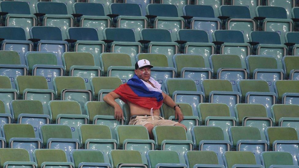 A Russia supporter reacts after the team lost the Russia 2018 World Cup quarter-final match against Croatia at the Fisht Stadium in Sochi, 7 July 2018