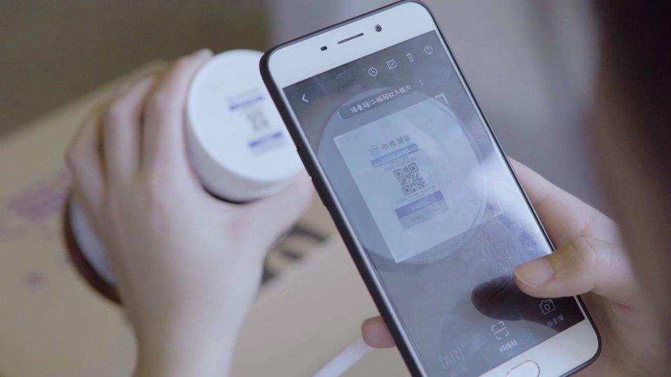 Woman checking pill bottle with app