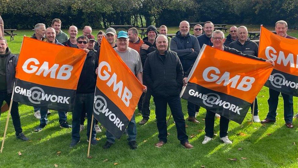 Workers stood holding flags