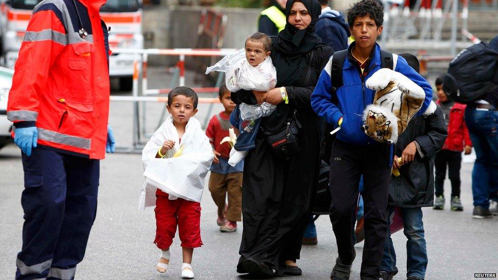 Migrants makes their way to wait for buses after arriving by train at the main railway station in Munich, Germany (September 7, 2015)