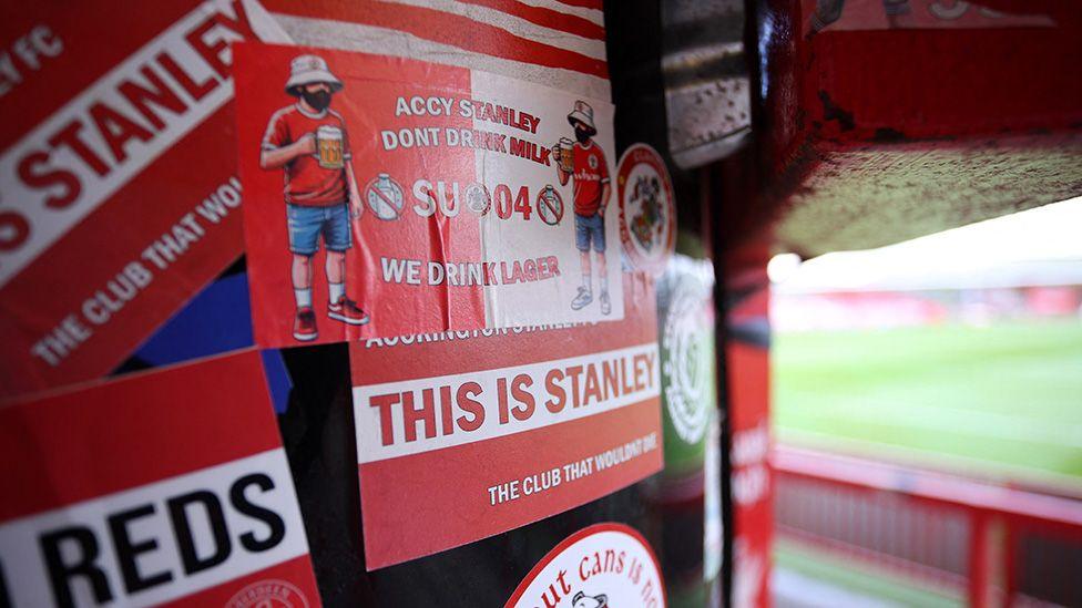 Lots of red-and-white Accrington Stanley stickers on a drum inside the stadium