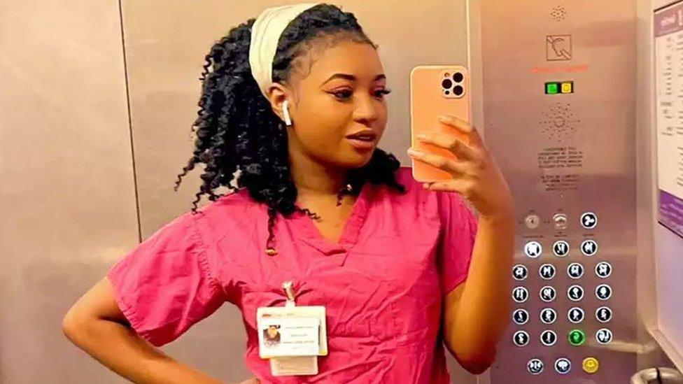 Owami Davies in pink nurses scrubs uniform