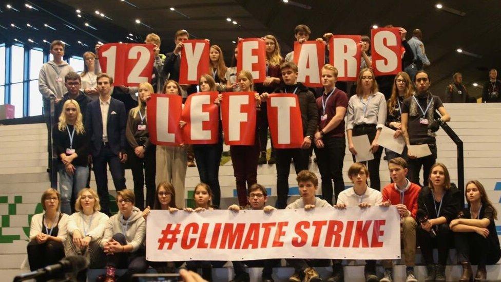 Demonstrators hold a slogan at UN climate talks in Katowice, Poland