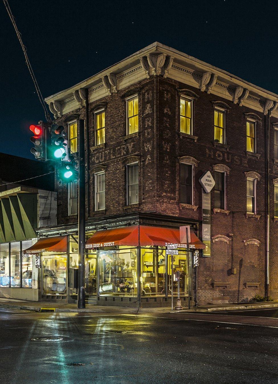 A night view of a closed barber shop on an empty street