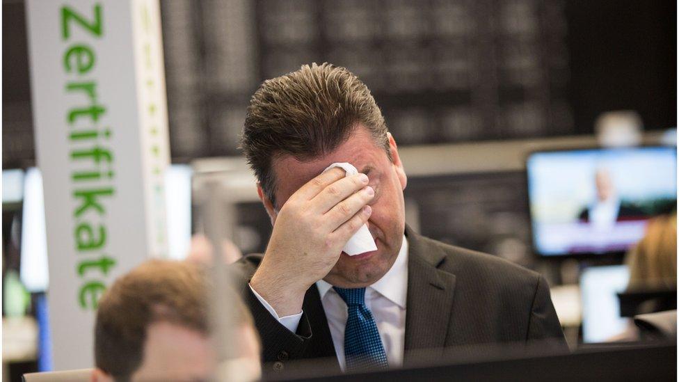 Trader Robert Halver of Baader Bank wipes his brow as the Frankfurt stock exchange falls (24 June)
