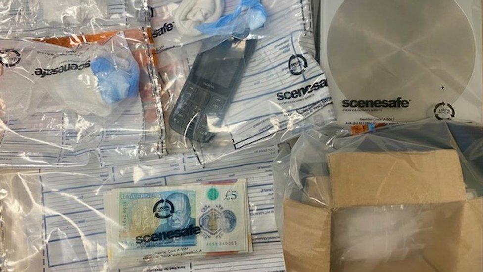 Police evidence bags containing a mobile phone, scales and cash