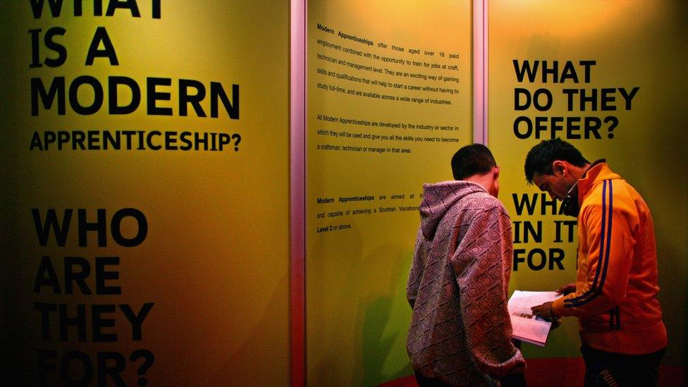 Young men next to a stand with information about apprenticeships