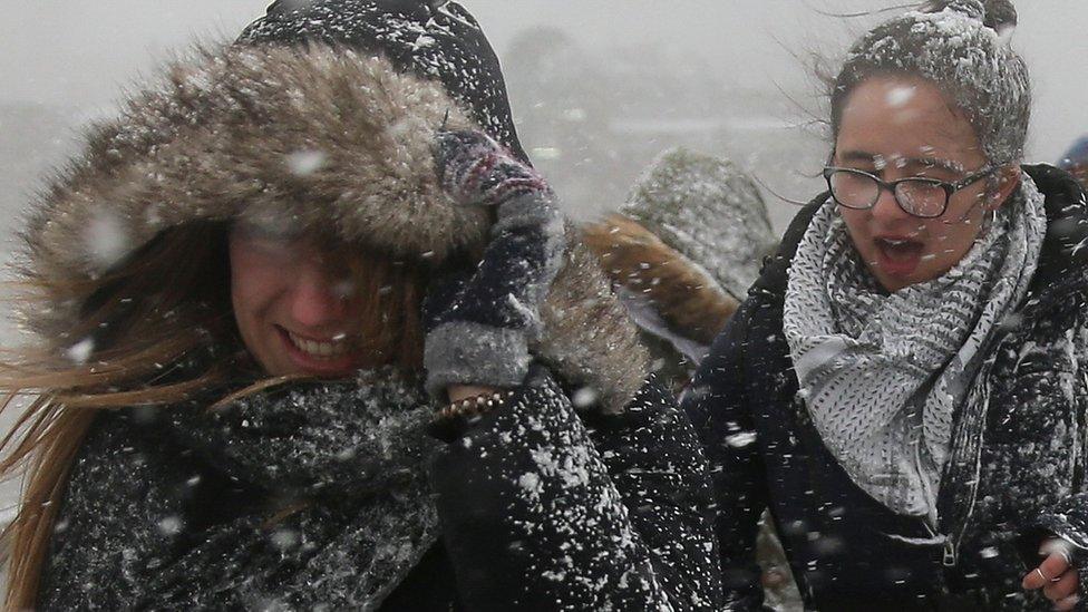 Two women getting covered in snow