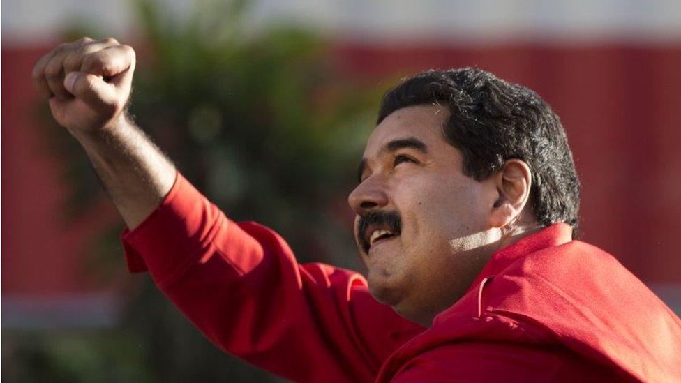 President Nicolas Maduro gestures to supporters from the top of a car after the inauguration of cable car public transportation system in Caracas on 1 December, 2015