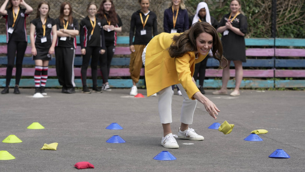 Catherine, Princess of Wales throwing a bean-bag with students behind her