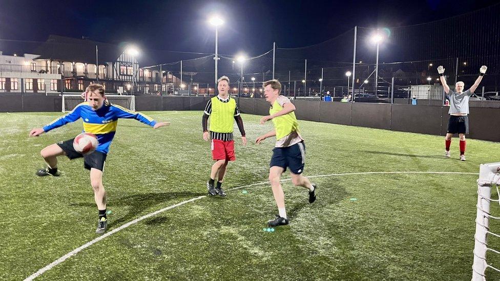 Football players on a pitch under floodlights at Imperial Sports Ground in South Bristol