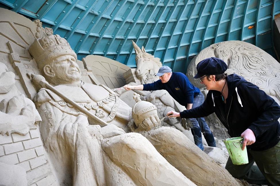 Sculptors Mark Anderson and Annette Rydin with their King Charles III sand sculpture at Weymouth beach