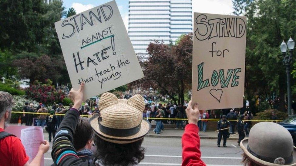 Anti-Trump demonstrators hold signs up across the street from a pro-Trump rally in Portland (05 June 2017)