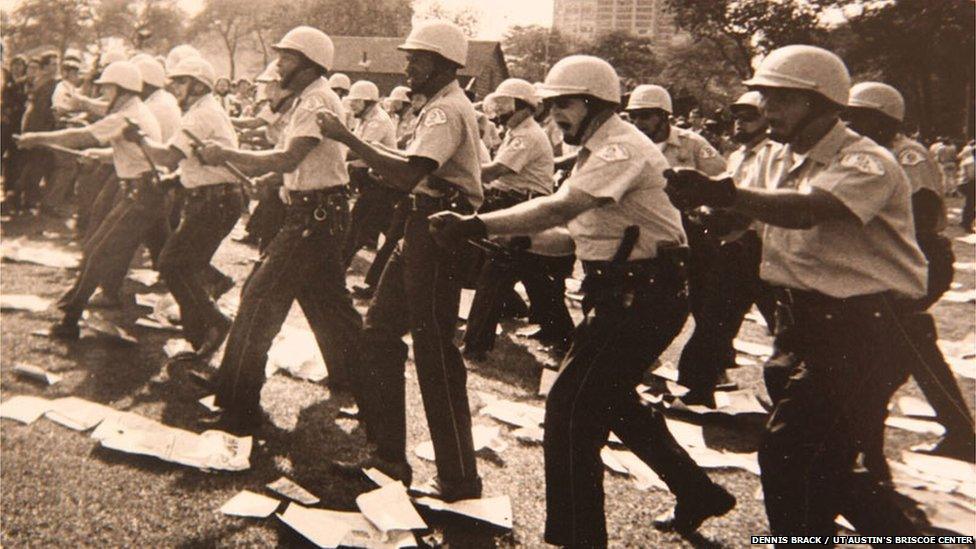 Policeman advancing against protestors during the 1968 Democratic National Convention in Chicago.