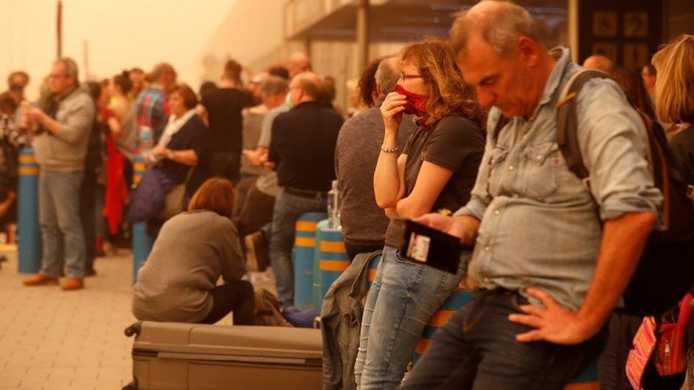 Stranded passengers wait at Las Palmas Airport in Gran Canaria, as a sandstorm disrupts travel