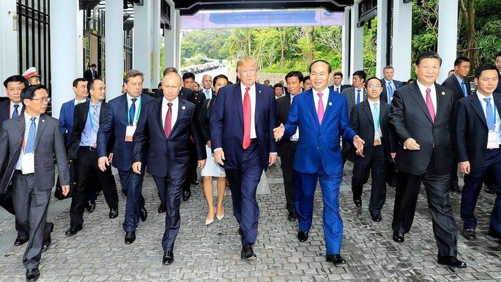 Donald Trump walks next to Vladimir Putin and other world leaders on the way to the "family photo" at the Apec summit