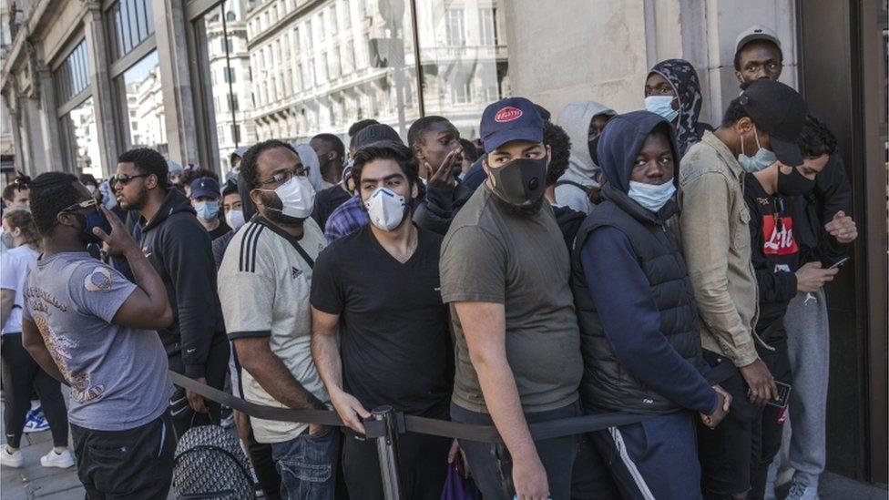 Shoppers queuing in London after restrictions lifted