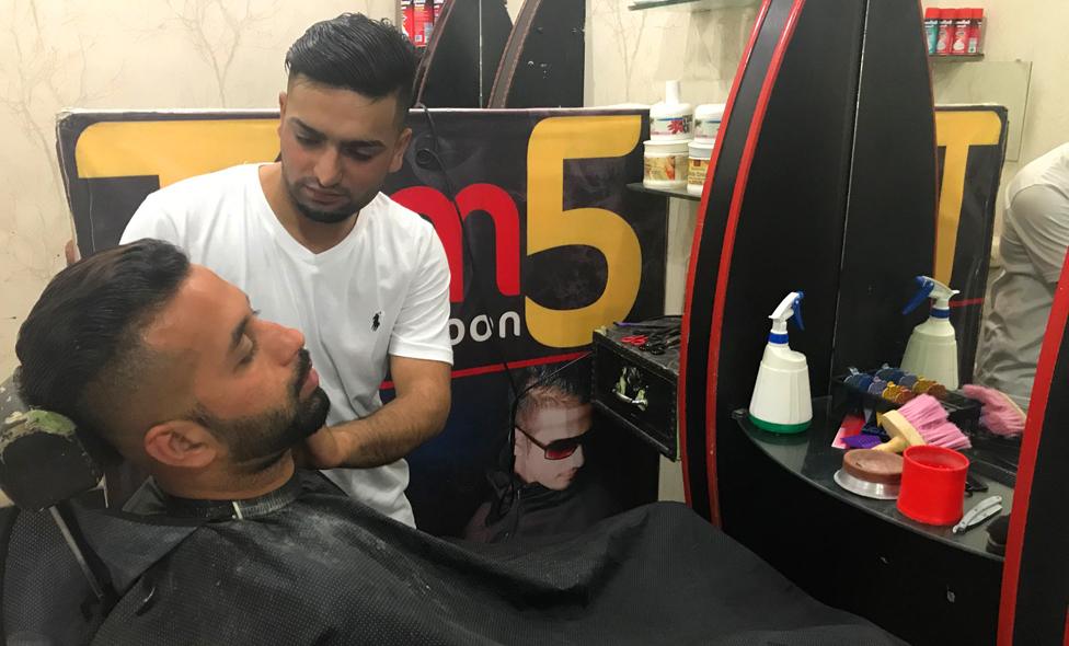 A barber with a customer in Mirpur