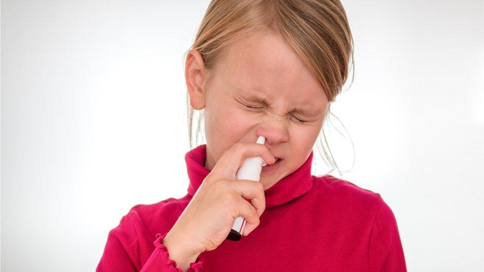 Girl using a nasal spray