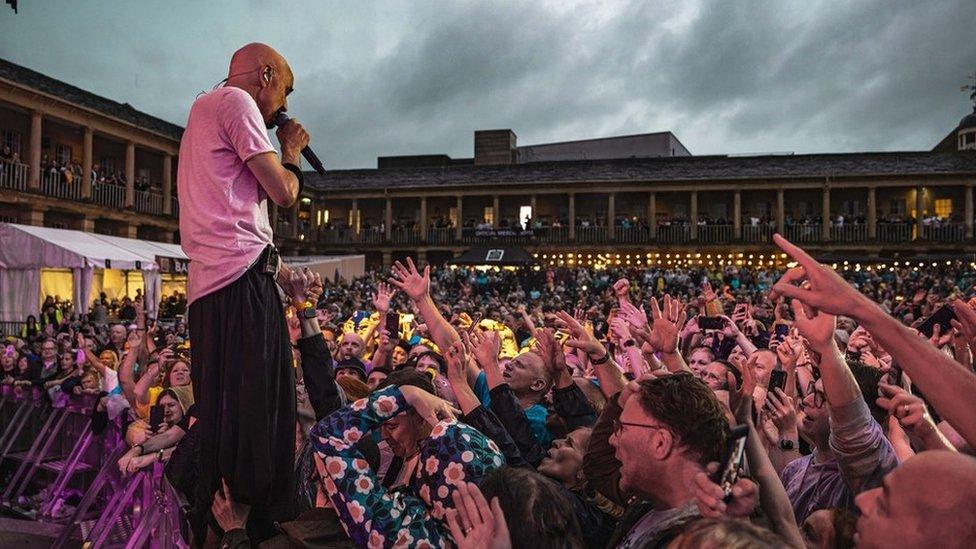 Tim Booth on stage with the crowd going wild