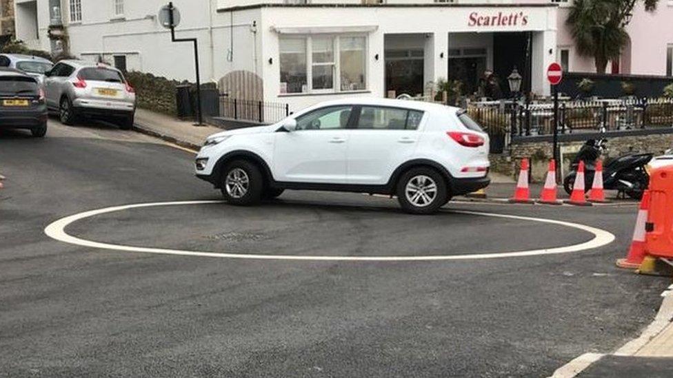 A car driving around the painted circle on Clevedon seafront