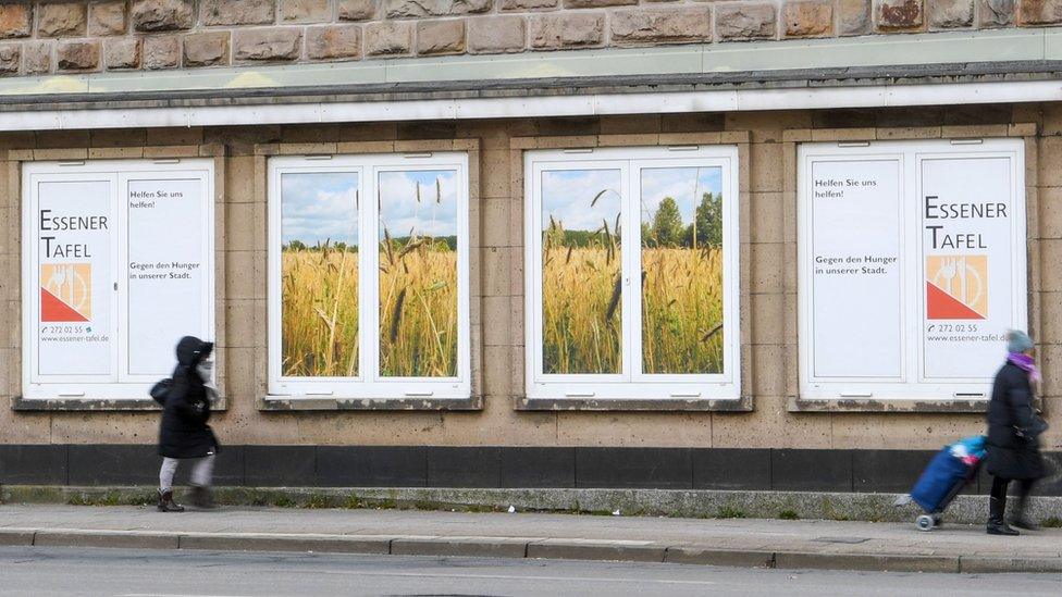 People pass by the "Essener Tafel" (Essen Foodbank) building in Essen