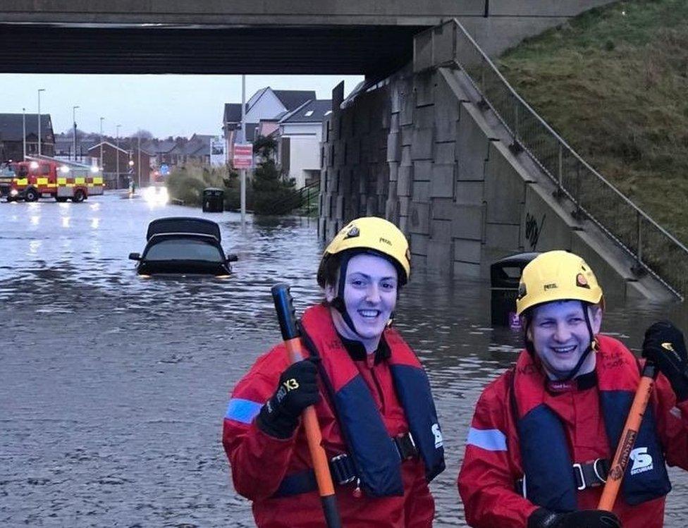 Firefighters after rescuing a motorist from flooding